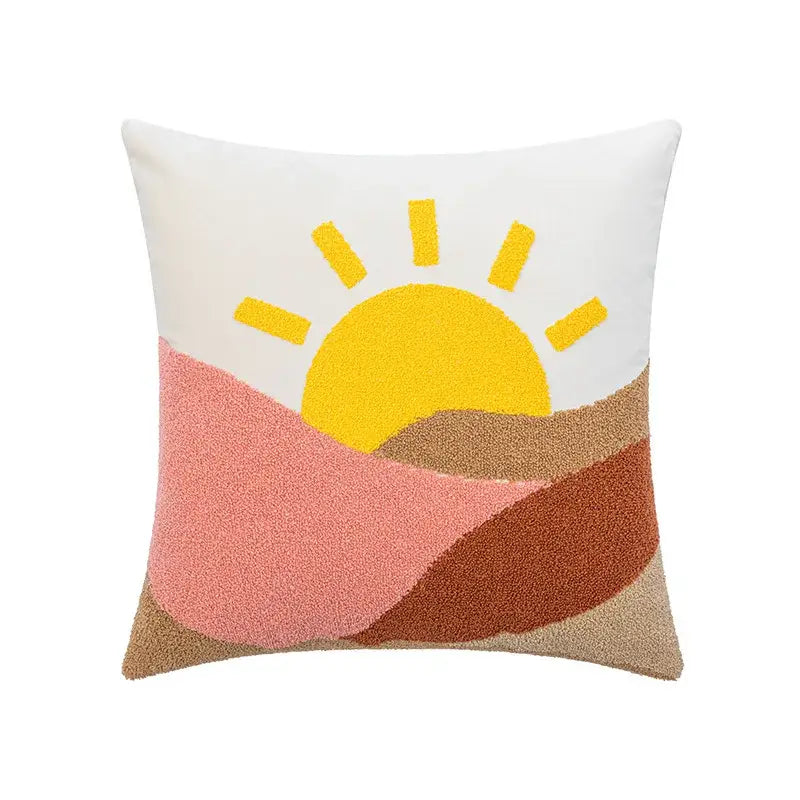 White cushion cover with textured cartoon abstract embroidery of sun rising over layered pink and brown hills for decorbites