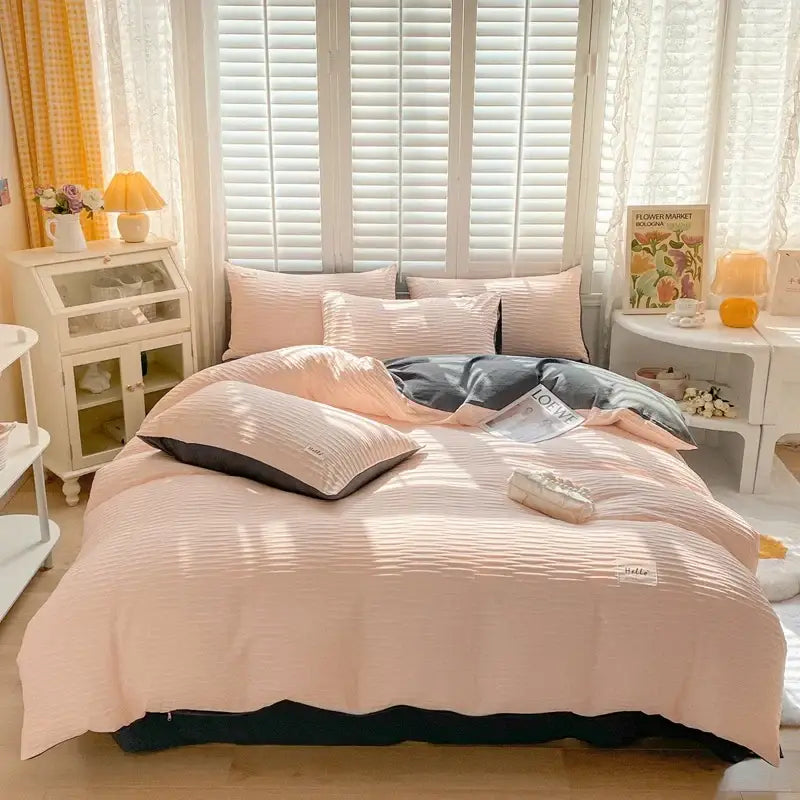 Pink ribbed duvet cover set with dark gray accent blanket and matching pillows in cream ribbed bubble yarn cover set
