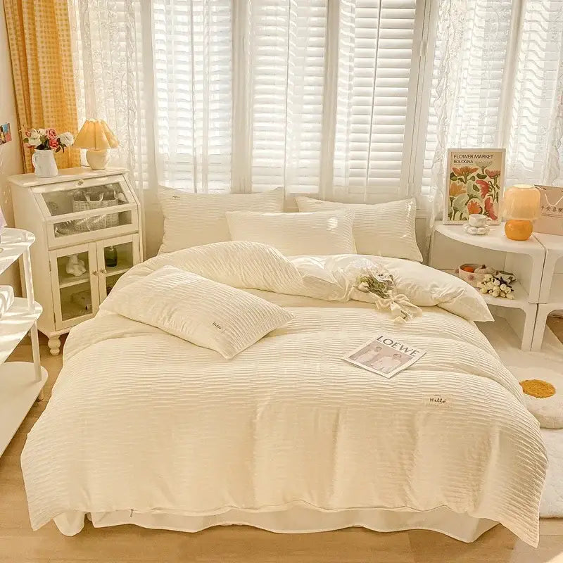 Cream ribbed bubble yarn fabric bedding set with subtle embroidered branding on pillows and comforter for bedroom decor