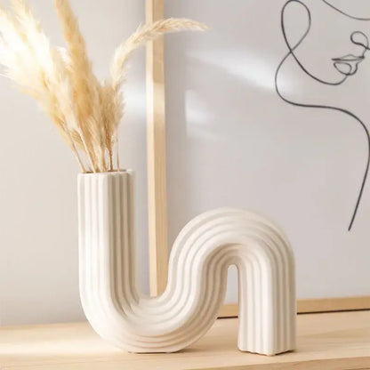 Cream ribbed geometric ceramic vase with sleek curved s shape for living room decorbites geometric decor