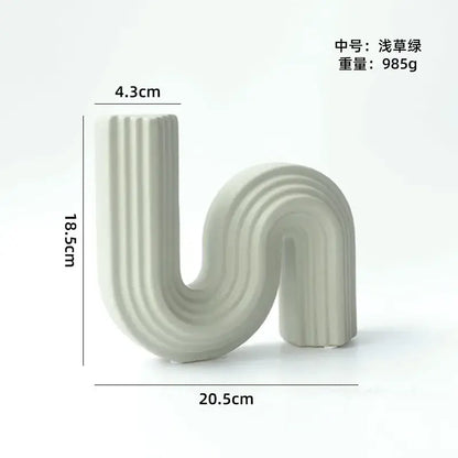 A sleek light grass green decorbites geometric ceramic vase with s shape curve and vertical ridges for living room decor