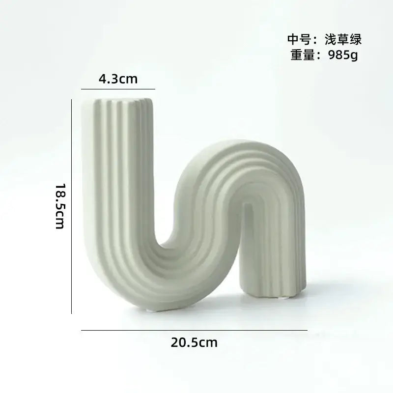 A sleek light grass green decorbites geometric ceramic vase with s shape curve and vertical ridges for living room decor