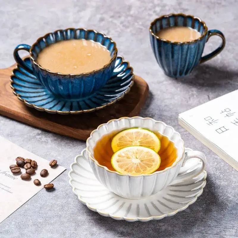Blue ceramic afternoon tea cup with fluted rim and gold trim filled with coffee on matching saucer decorbites ceramic afternoon