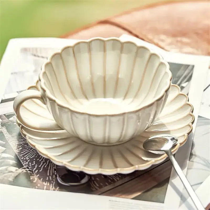 Cream scalloped ceramic afternoon tea cup and saucer with gold-toned ridges for elegant ceramic afternoon tea decorbites