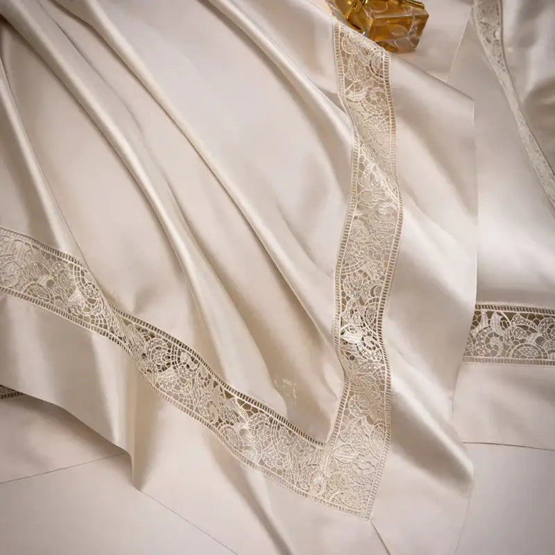 Cream-colored satin bedsheet with delicate lace trim in decorbites damask lyocell cotton bedding set