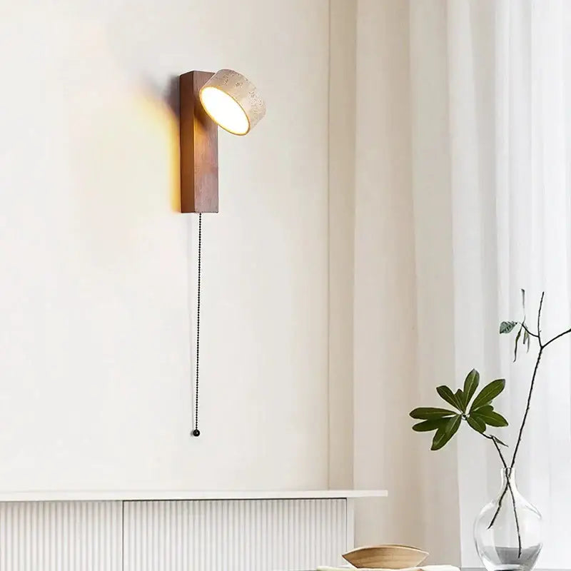 Warm-toned wooden wall sconce with textured off-white ceramic lampshade and black pull chain for cream style bedside lamp decorbites cream style