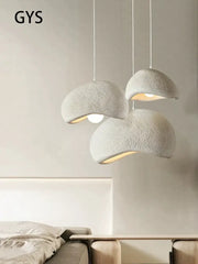 Three off-white textured cream style cloud pendant lamps hanging as dining room decorbites cream style lighting