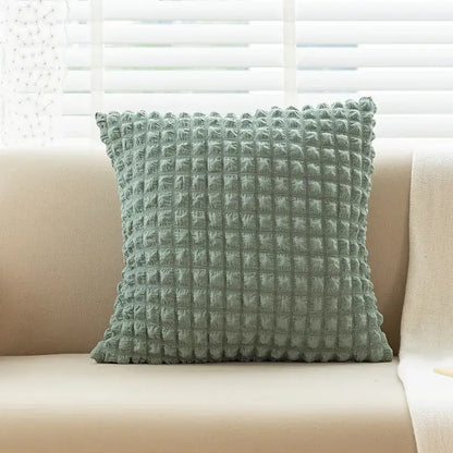 A soft sage green elastic puff plaid cushion cover with a textured quilted surface for living room decor