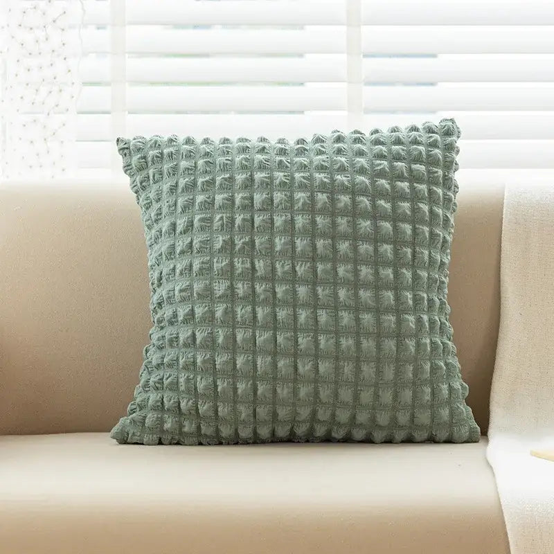 A soft sage green elastic puff plaid cushion cover with a textured quilted surface for living room decor