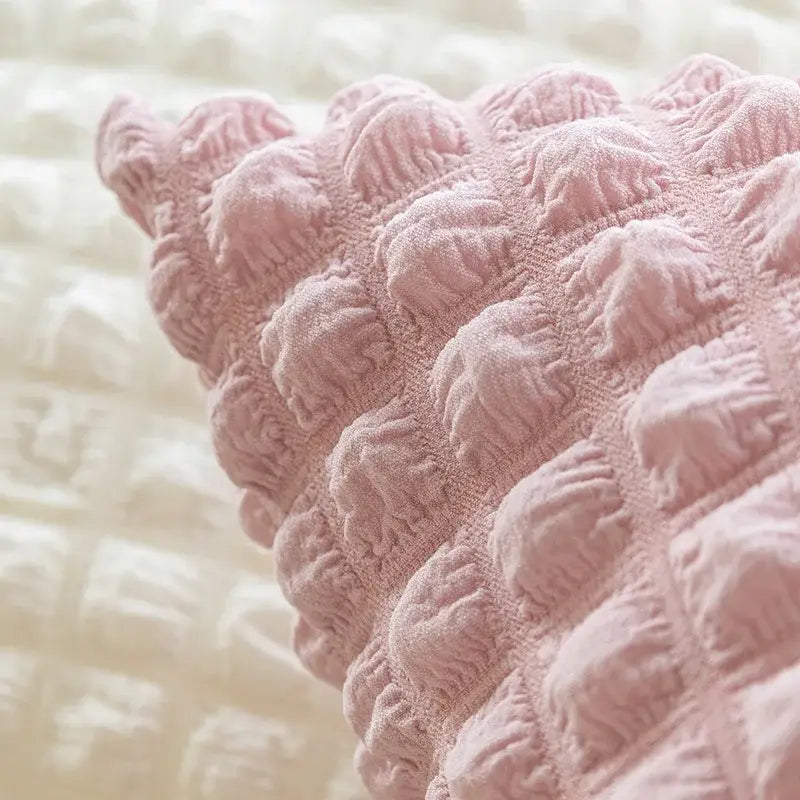 Soft pink textured cushion cover with ruched quilted design featuring elastic puff plaid for living room decor