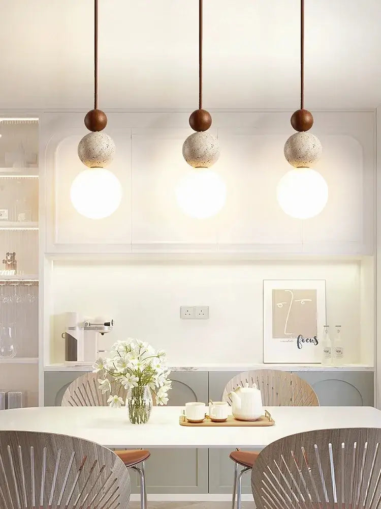 Three modern cream style led pendant lamps with matte brown tops and textured concrete spheres for bedroom decorbites decor