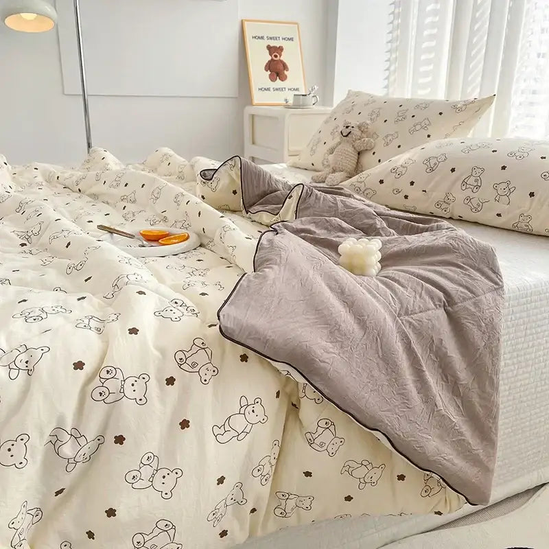 Cream teddy bear breathable double gauze quilt with black and brown bears paired with soft gray fleece blanket