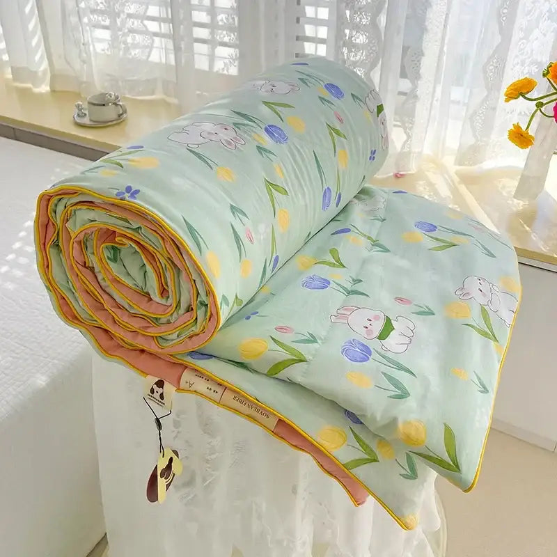 A soft mint green breathable double gauze quilt with cartoon bunnies and floral pattern featuring pink and yellow edges