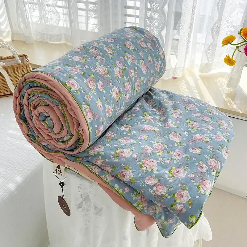 A soft cream teddy bear breathable double gauze quilt with blue background and pink floral pattern for bedroom bedding