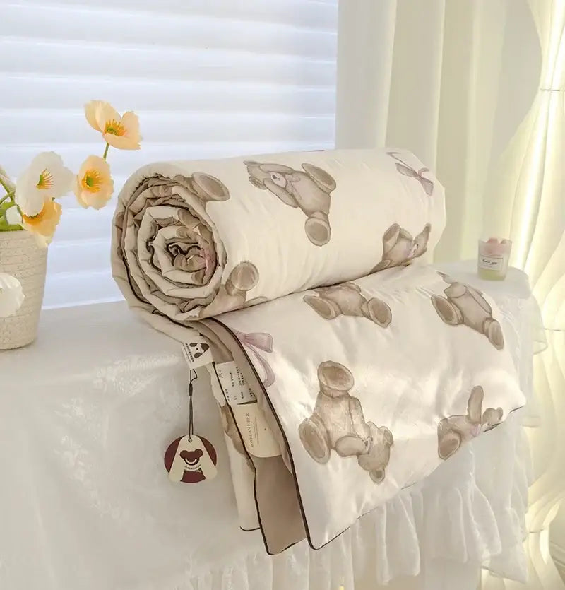 A soft cream teddy bear quilt featuring breathable double gauze fabric with stitched beige bear patterns for bedroom bedding
