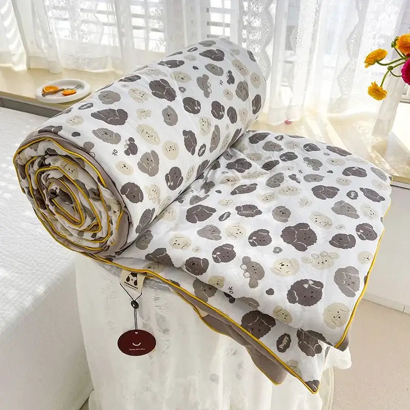 A soft white double gauze quilt with gray and beige cartoon poodles and yellow piping for breathable double use