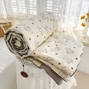 A cream teddy bear breathable double gauze quilt with black bear outlines and brown flowers for bedroom bedding