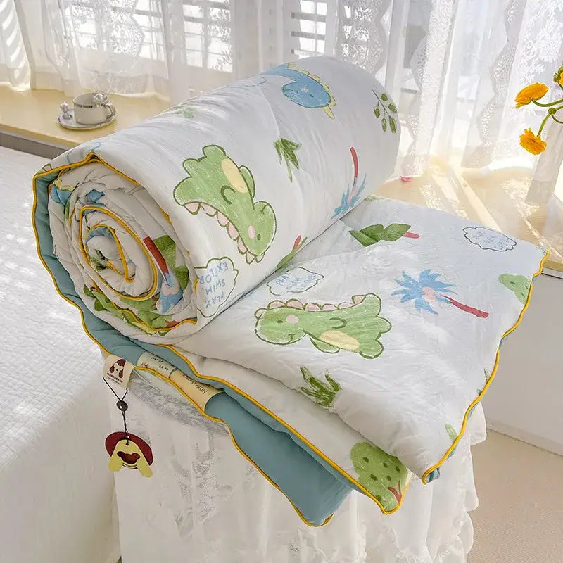 A cozy cream teddy bear double layered soya fibre quilt with green and blue dinosaur prints and yellow trim rolled on bed