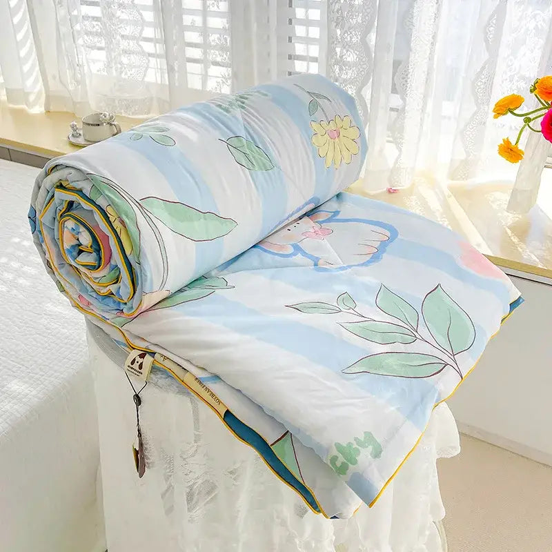 A soft cream teddy bear double layered soya fibre quilt with light blue and white stripes and pastel floral patterns
