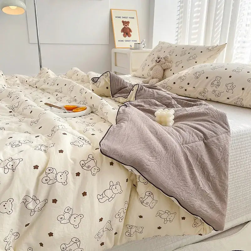 Cream double layered soya fibre quilt with playful black and brown teddy bear pattern paired with soft gray fleece blanket