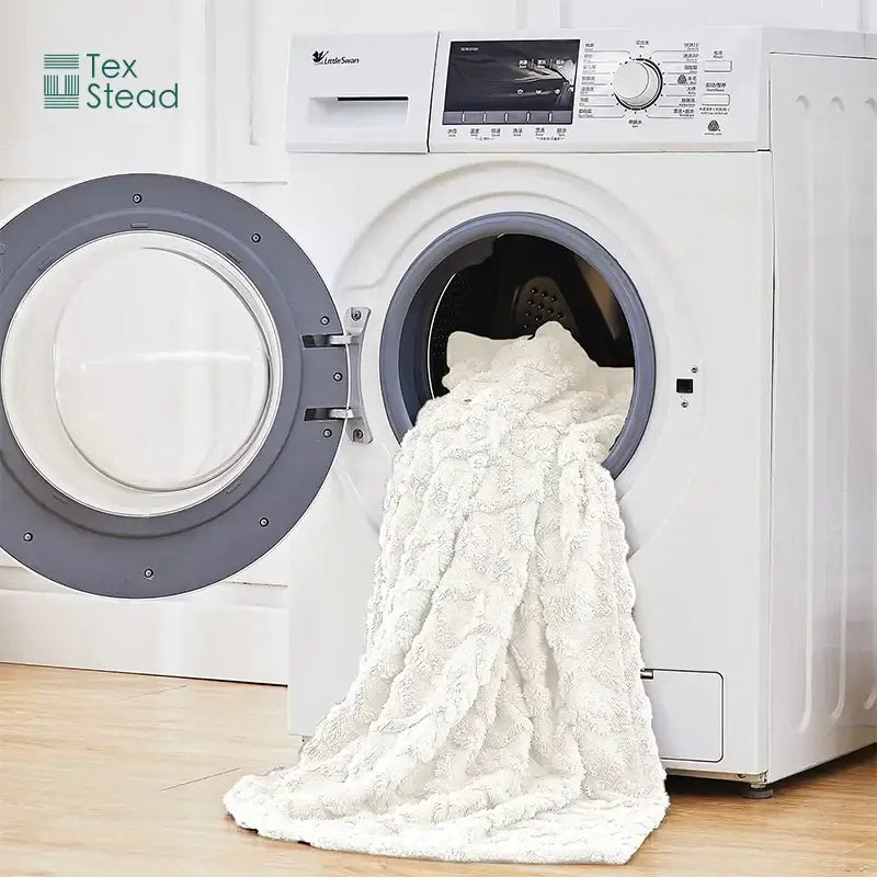 A cream textured cable knit cozy knit blanket by decorbites being unloaded from a washing machine for bedroom use