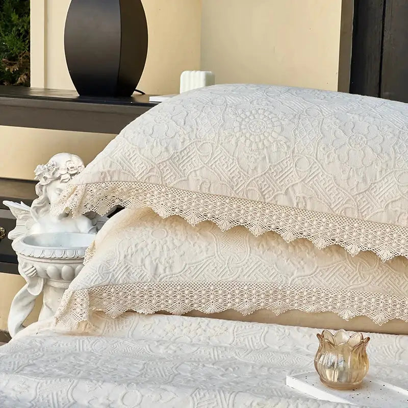 Cream textured cotton quilted bedspread set with cream-colored embroidered pillowcases and delicate lace trim