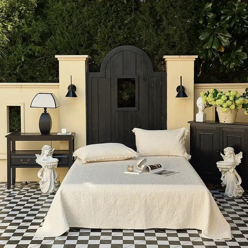 Cream textured cotton quilted bedspread set with lace draped over an outdoor bed showcasing cotton quilted bedspread decorbites