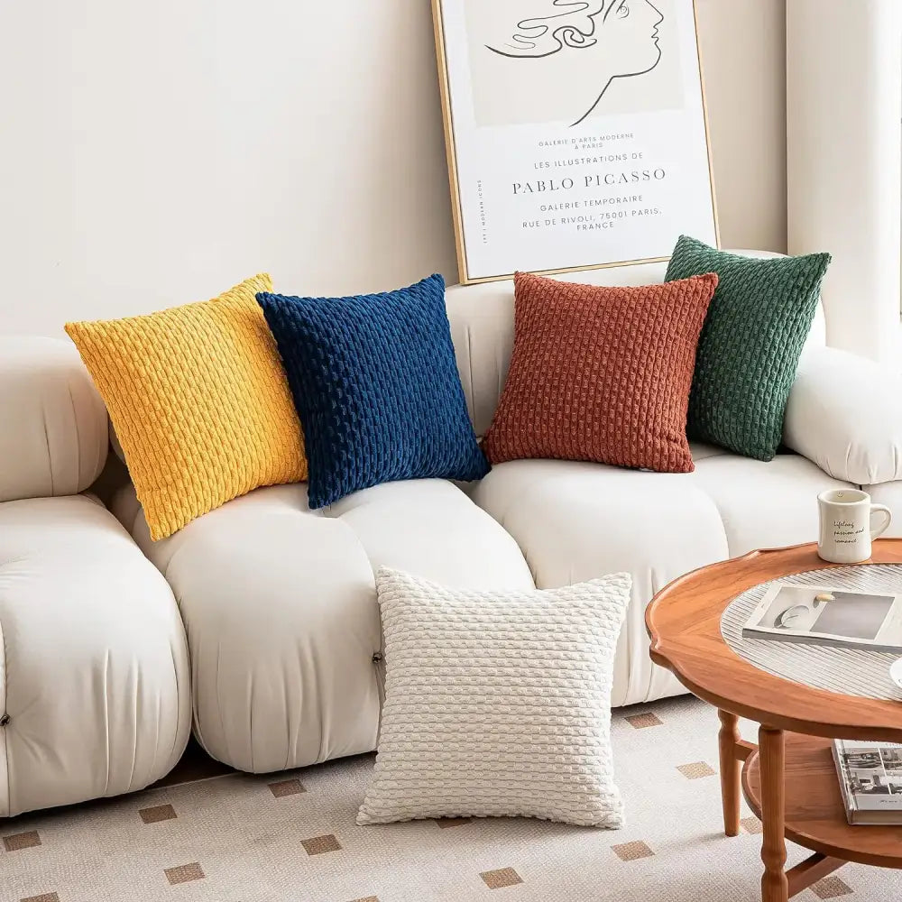 Four colorful textured throw pillows in yellow blue rust and green enhance living room decor with decorative pillow covers