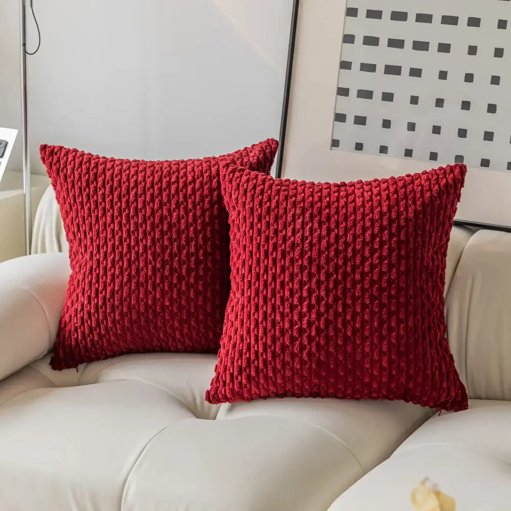 Two vibrant red chunky-knit decorative pillow covers with ribbed texture on white sofa for decorbites pillow cover decor
