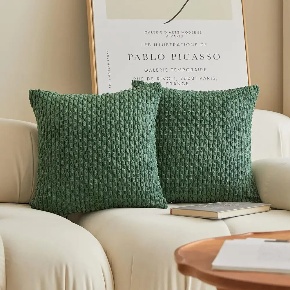 Two emerald green textured knit decorative pillow covers with a woven pattern on a cream sofa decorbites pillow cover