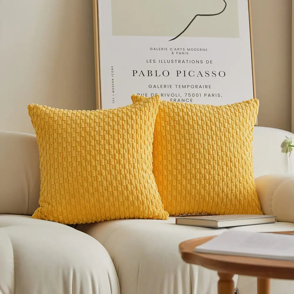 Two vibrant yellow textured knit decorbites decorative pillow covers with ribbed fabric on a light sofa for living room decor
