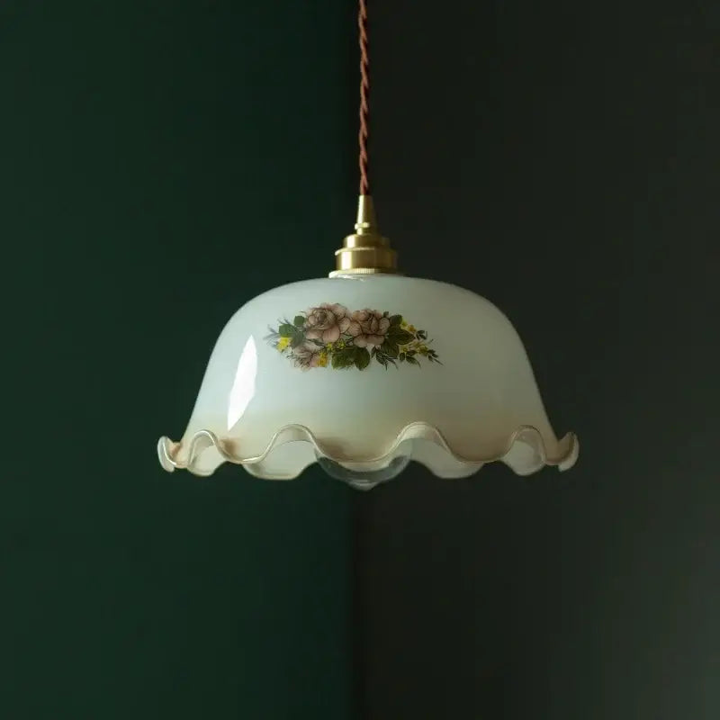 Cream vintage brass pendant light featuring a cream-colored glass shade with floral design and scalloped edge for dining room decor