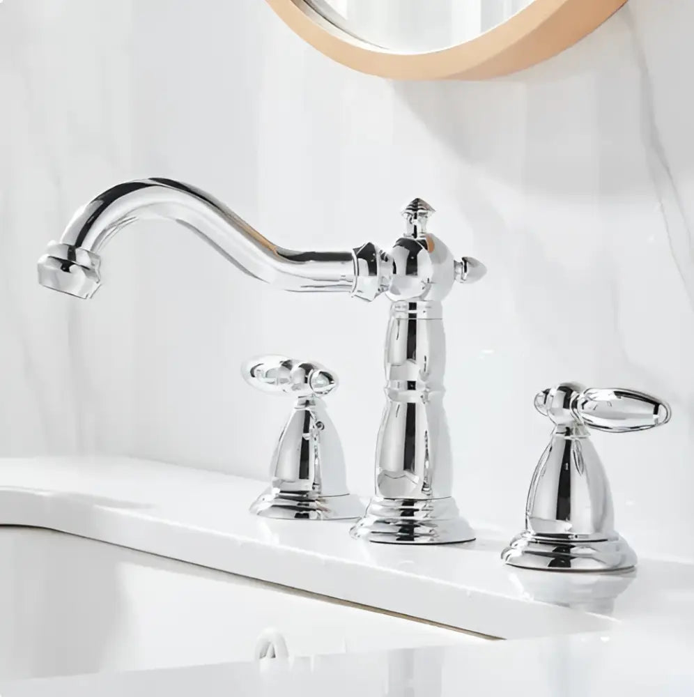 Cream white bathroom set featuring chrome-finished vintage style faucet with ornate detailing and two handles and towel rack