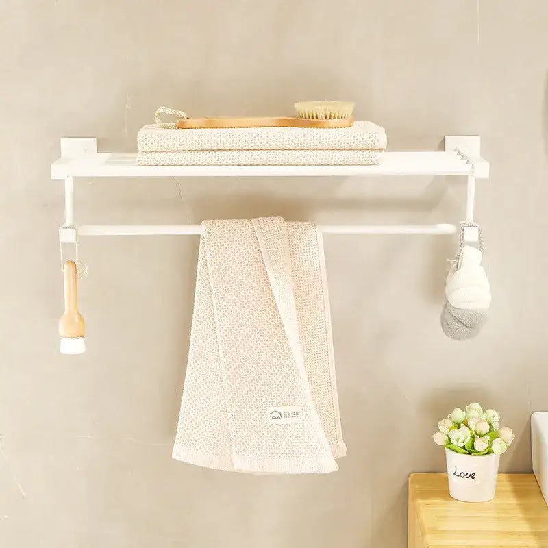 Cream white bathroom set with wall-mounted shelf towel rack holding beige towel and wooden bath tools