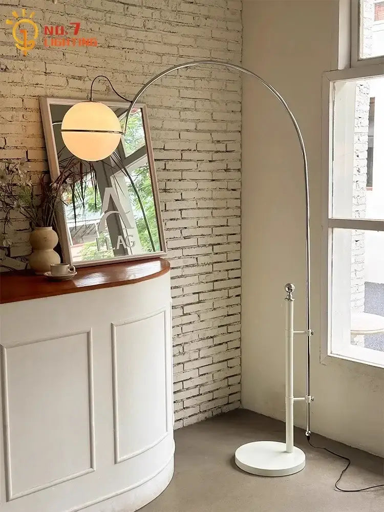 A cream wind floor lamp with a sleek arched chrome frame and warm-toned glass globe shade for decorbites cream wind