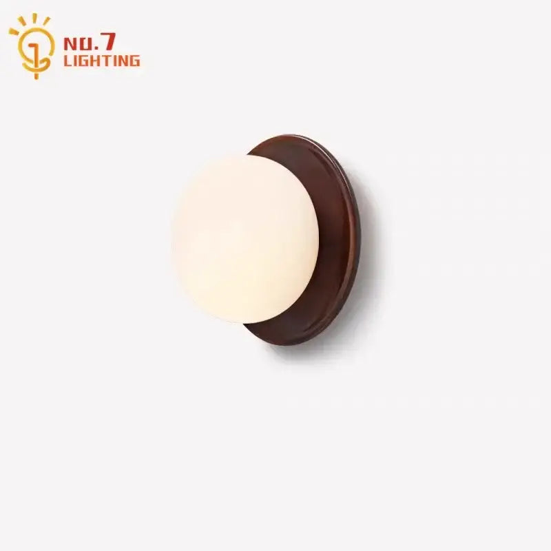 Warm-toned spherical glass wall light with dark brown wooden base by no.7 lighting for bedroom decorbites cream wind dumplings