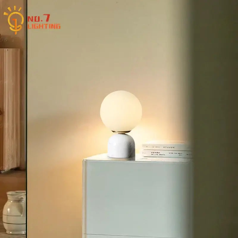 Minimalist cream wind marble table lamp with a white marble base and spherical glass shade for bedroom decorbites cream wind