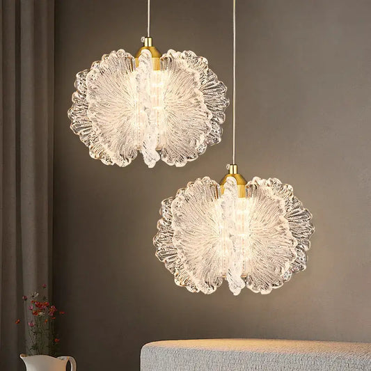 Two elegant creamy acrylic flower pendant lights with translucent petal design and gold fixtures as decorative focal point