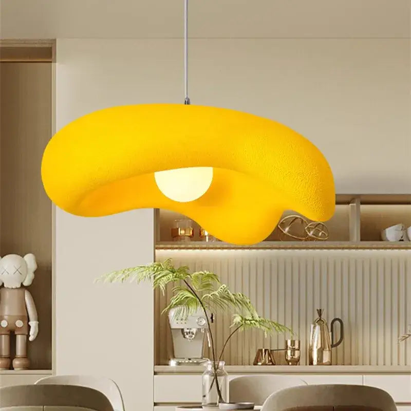 A vibrant yellow creamy style pendant light shaped like a cloud with textured surface and soft glow for dining room decorbites