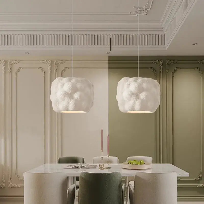 Two white creamy style pendant lights with textured cloud shapes hang from the ceiling as decorbites pendant lights