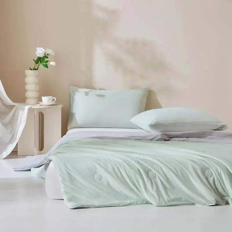 A soft mint green quilted ice cream silk duvet with subtle button detailing from decorbites cream silk quilt collection