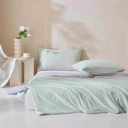 A soft mint green quilted ice cream silk duvet with subtle button detailing from decorbites cream silk quilt collection