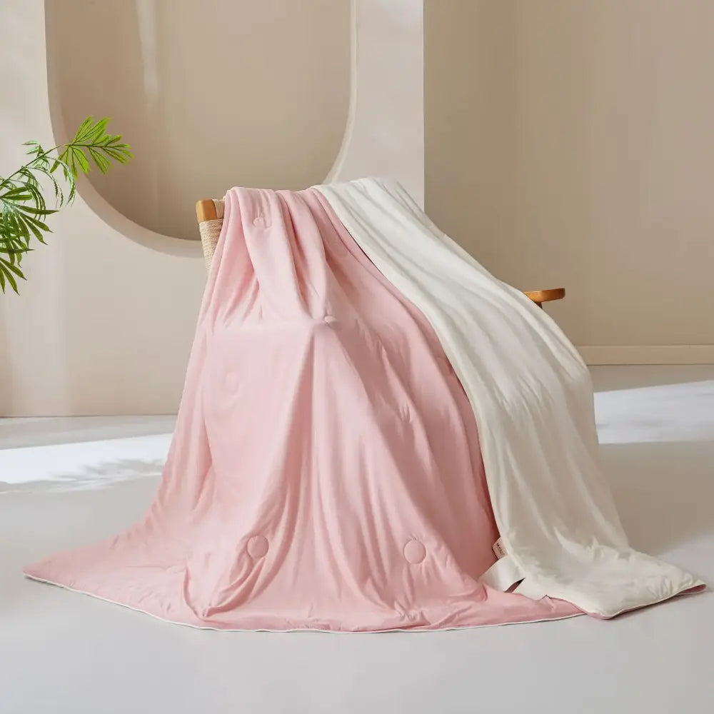 A soft pink and white quilted blanket with subtle circular stitching details from decorbites ice cream silk quilt collection