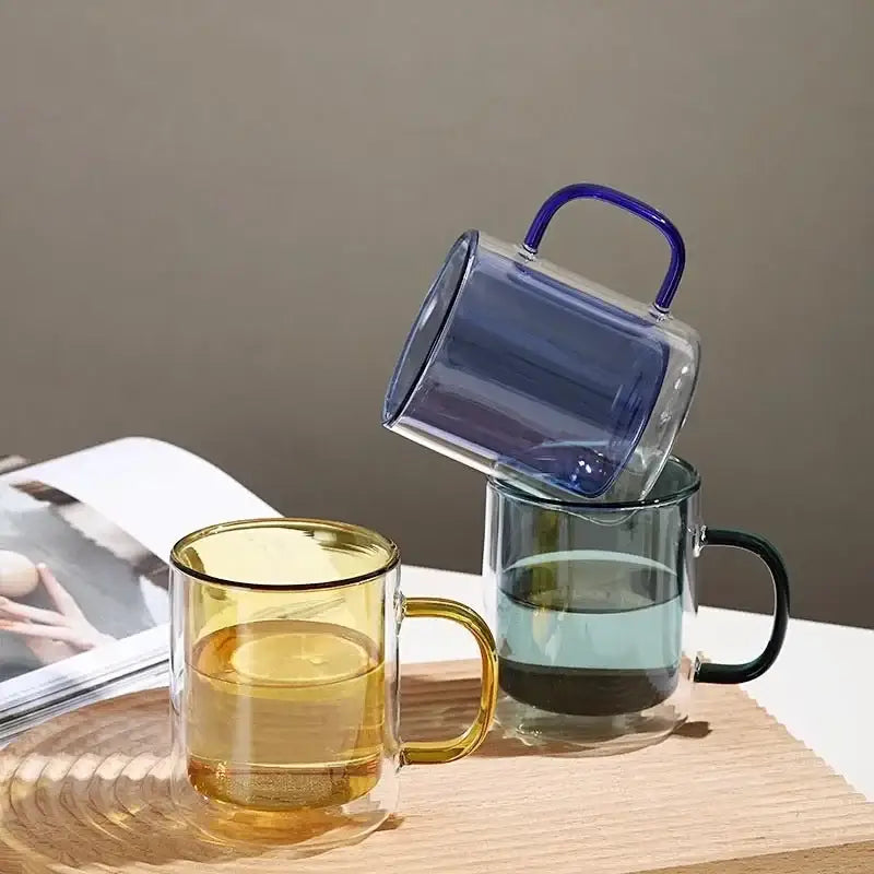 Three double-walled glass whiskey wine glass tumblers in yellow green and blue with matching handles for dining room use