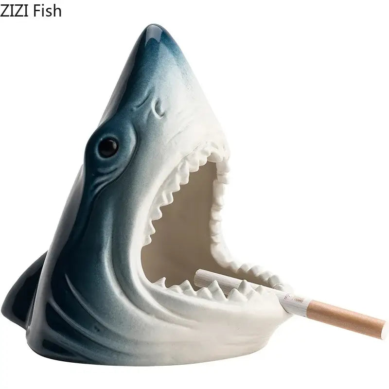 A ceramic decorbites creative shark storage ashtray in glossy blue and white with detailed teeth holding a cigarette