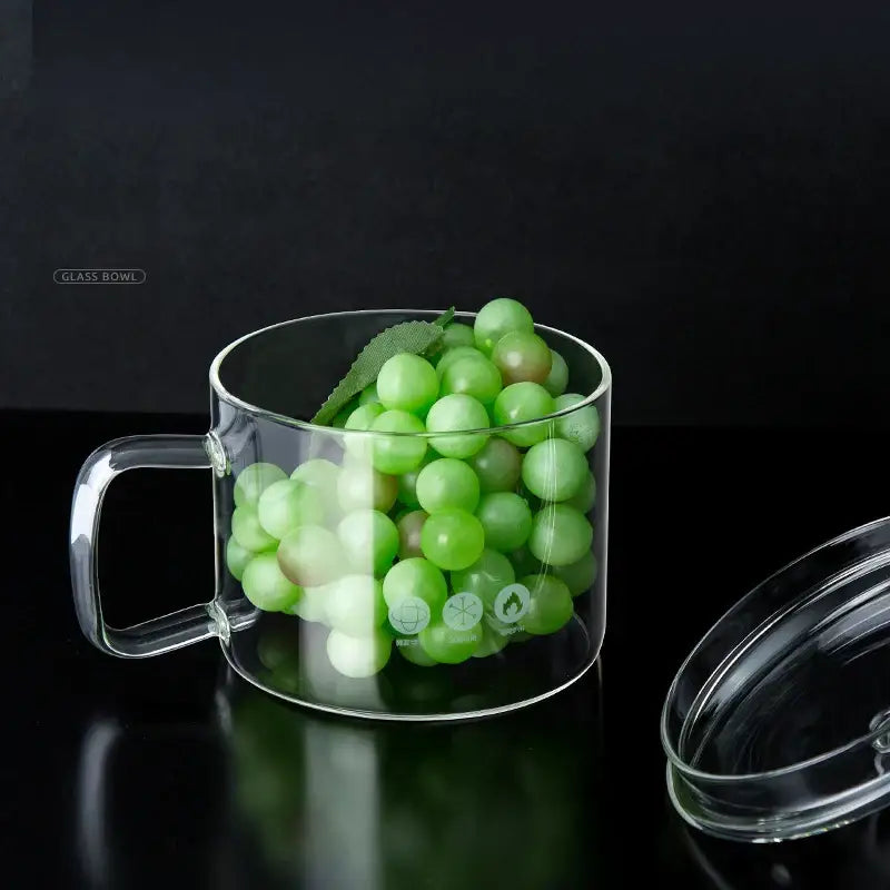 Creative clear glass salad bowl with handle filled with green grapes garnished with a leaf for kitchen and dining room