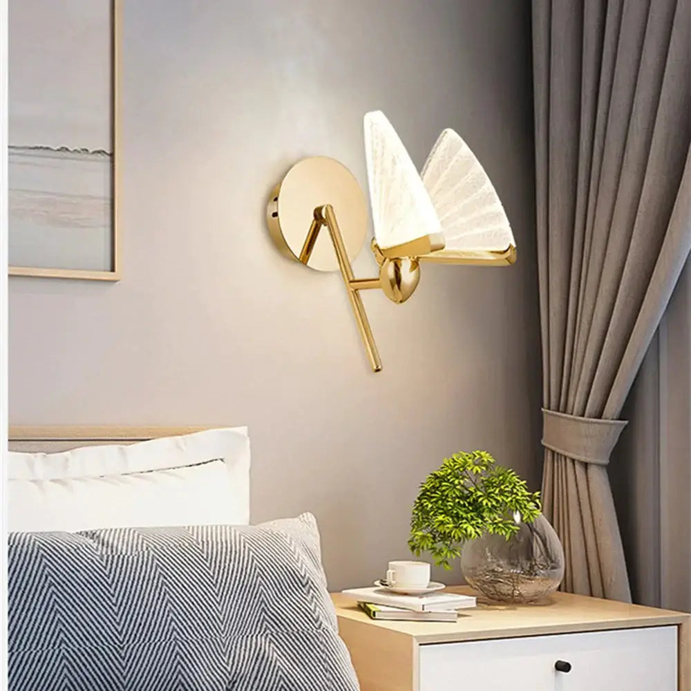 Gold-toned wall sconce with two fan-shaped frosted glass shades for a creative colorful butterfly led bedroom lamp