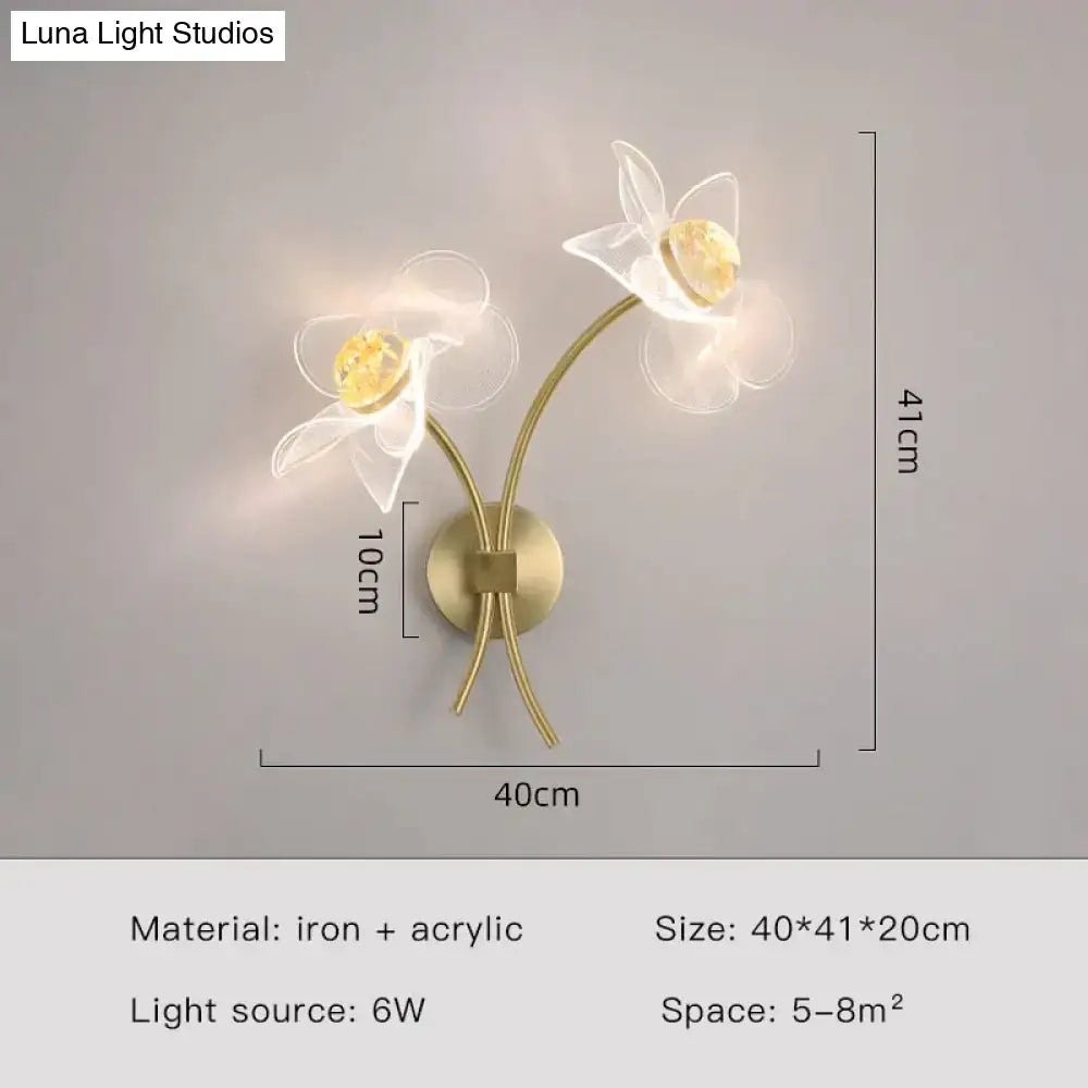 Brass-toned floral decorative gold led wall lamp with two white acrylic flowers and golden-yellow crystal centers for bedroom