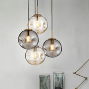 Modern creative glass chandelier with smoky gray globe, gold accents, black cords, and led lamp for restaurant window use