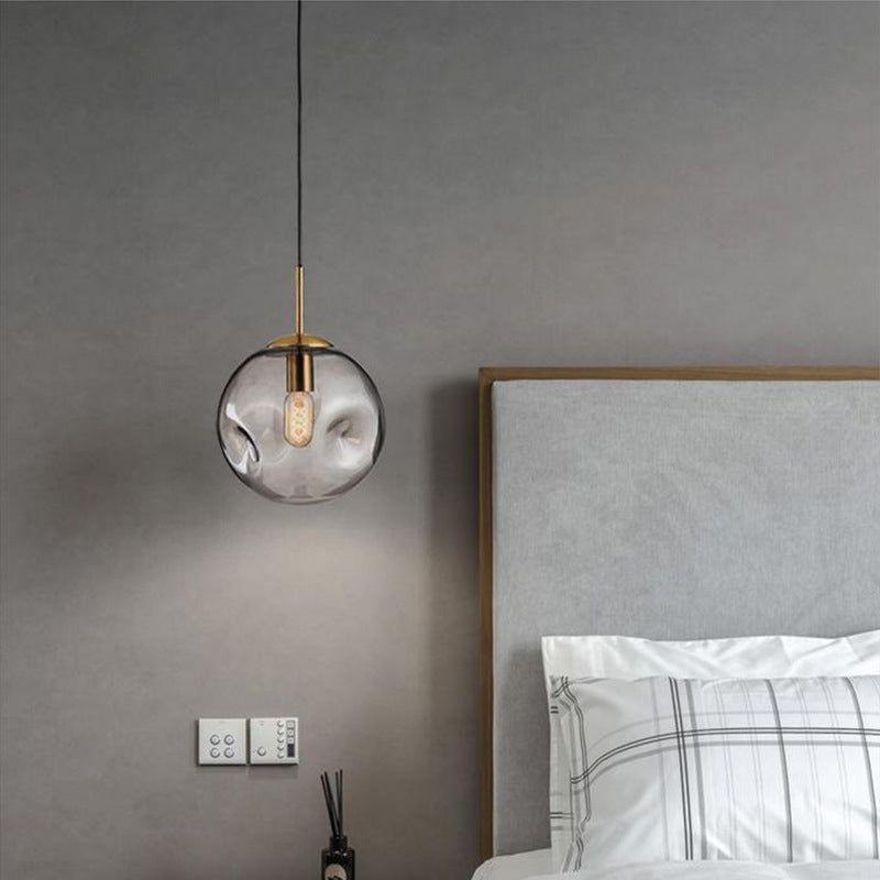 Modern gold and glass pendant light with a marble-like pattern.